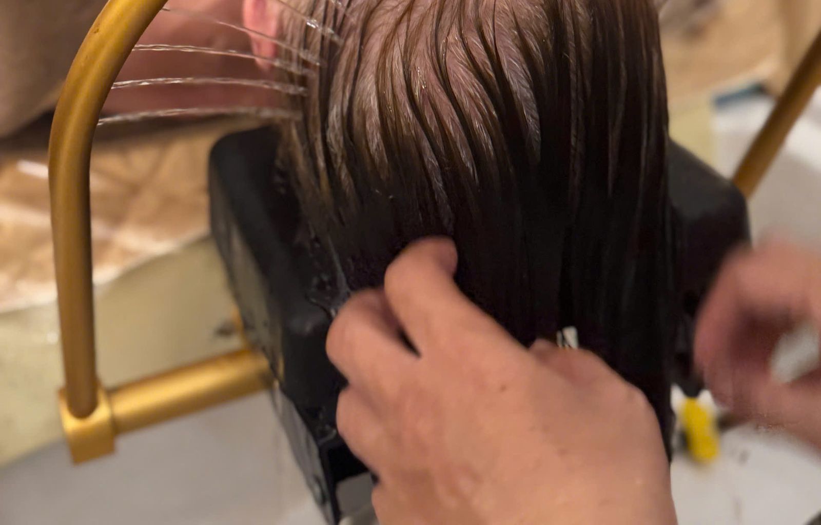 Head spa at Spa Lux Nha Trang — hair rinsed under the gold water arc