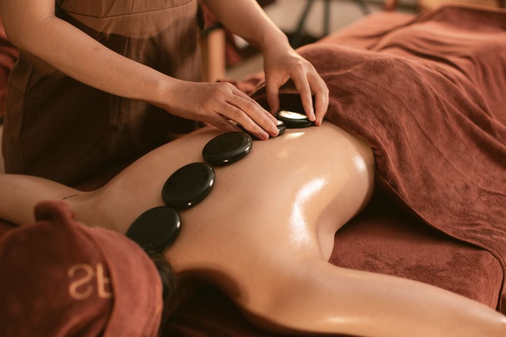 Heated stones on the back during a hot stone massage